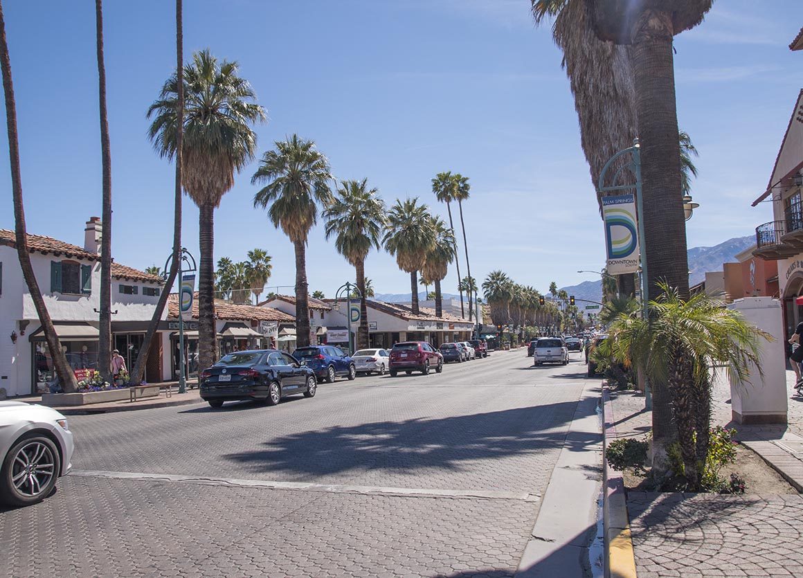 Palm Canyon Drive in downtown Palm Springs, lined with palms and parked cars. Sunday night's crash happened in the city's north end, at Sunrise Way and Vista Chino.